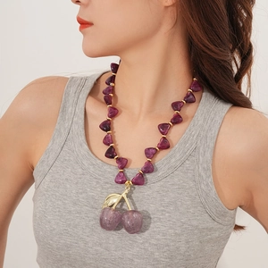 Detail of purple acrylic cherry pendant necklace with glitter finish on model