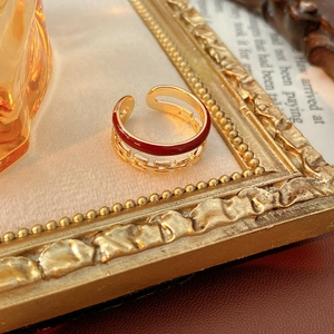 Detail view of a vintage double-layered ring with red enamel and golden chain texture