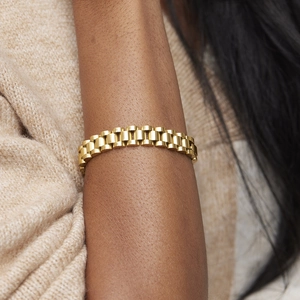 Macro detail of 18k gold plated stainless steel watch-style link bracelet on wrist