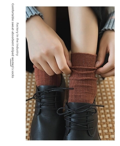 Detail view of retro rust red ribbed knit crew socks with elastic cotton texture
