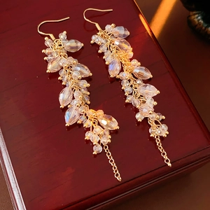 Macro shot of gold tassel earrings featuring multifaceted iridescent crystal beads