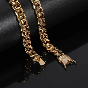 Macro shot of gold plated Cuban chain link with diamond encrusted buckle detail