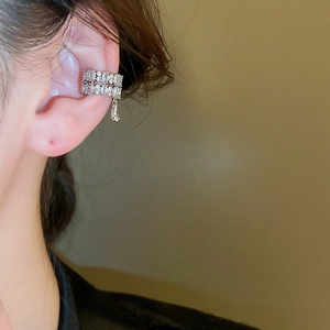 Close-up of double-layer silver ear cuff with micro-pave zircons and a teardrop pendant