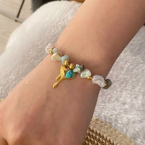 Natural stone beaded bracelet with gold heart pendant worn on wrist for a boho look