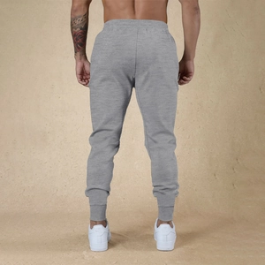 Vista posterior de pantalones jogger grises ajustados con cintura elástica para hombre