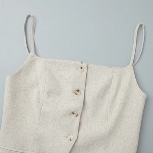 Detail of linen tank top showing button-front closure and oatmeal fabric texture