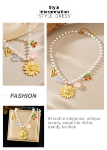Detail of pearl chain necklace with sunflower, cherry and heart pendants on sand texture