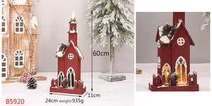 Detail of red wooden Christmas church with snow effect and warm LED lights, 60cm height