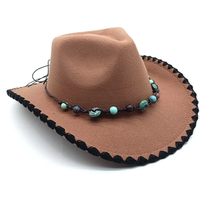 Close-up of brown western felt hat with black stitched brim and ethnic beadwork trim