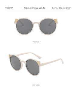 Detail of cream white cat-ear kids sunglasses with golden triangle accents and gray lenses