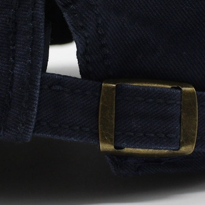 Detailed macro view of dark blue cotton twill fabric with vintage bronze metal buckle