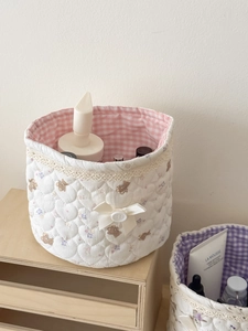 Detalle de cesta de almacenamiento acolchada con diseño de osos y forro de cuadros rosa