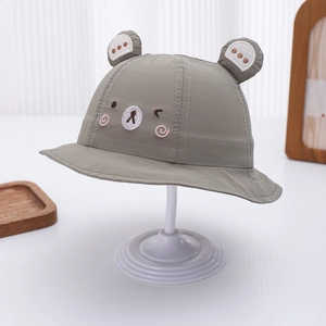 Close-up of grey baby bucket hat with cute bear ears and embroidery on white stand