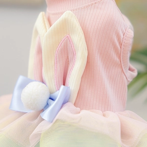 Detailed close-up of pink pet dress with rabbit ears and colorful rainbow mesh layers