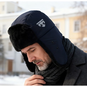 Detail of waterproof navy trapper hat with thick black faux fur lining and chin strap