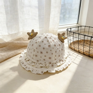 Détail d'un chapeau de soleil pour bébé crème avec imprimé marguerites et étoiles
