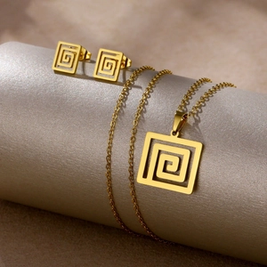 Close-up of golden necklace and stud earrings set featuring geometric square pattern