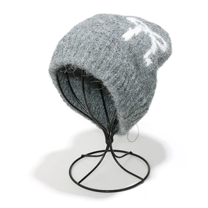 Detailed texture of dark grey mohair beanie featuring abstract white jacquard patterns