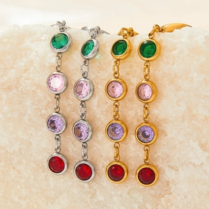 Detailed macro of gold and silver tassel earrings with vibrant multi-color zircons
