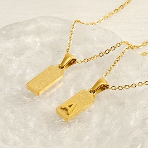 Gold rectangular pendant necklace with sandblasted finish and letter A engraving