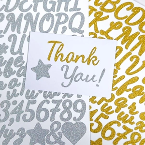 Macro detail of glitter gold and silver alphabet stickers for DIY graduation cap decor