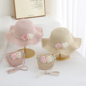 Close-up of woven sun hat and matching straw bag with floral accents and pearls