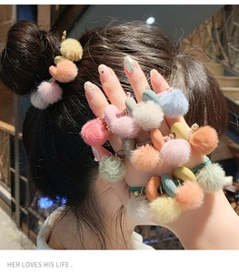 Dettaglio di elastici per capelli con pompon di peluche in tonalità pastello macaron