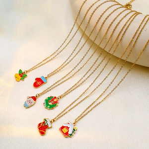 Macro detail of six Christmas themed gold steel necklaces with colorful enamel charms