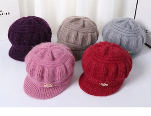 Detail view of knitted elderly women hats with short brims and metal bow accents