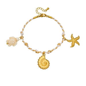 Braided rope bracelet with gold sea turtle, conch, and starfish pendants on white background