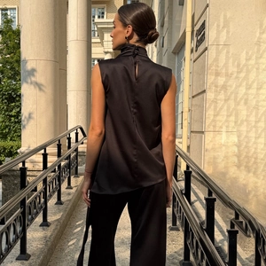 Elegant black satin sleeveless high neck top with button back details on model