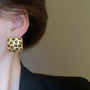 Nahaufnahme goldener quadratischer Leopard-Ohrring mit Bernstein-Kristall am Model