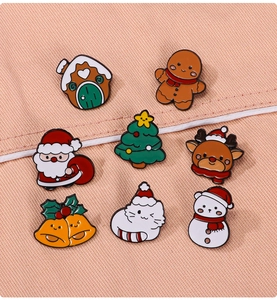 Detailed set of eight festive Christmas enamel pins on textured pink fabric background