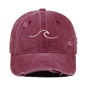 Detail of embroidered white wave pattern on maroon washed cotton baseball cap
