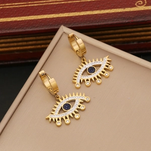 Golden evil eye hoop earrings with blue center stone on a beige jewelry box