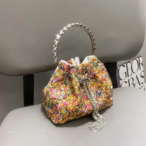 Detail of colorful rhinestone bucket bag with crystal metal handle and silver chain fringe