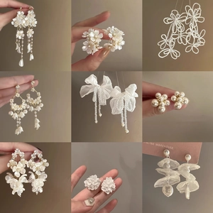 Detailed collection of pearl and flower tassel earrings in white and gold finishes