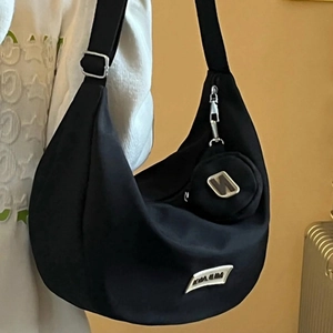 Large black nylon crescent crossbody bag with wide strap and matching round pouch