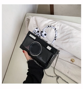 Detail of camera-shaped crossbody bag with polka dot scarf handle and silver chain strap