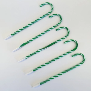 Detailed view of five green and white candy cane shaped ballpoint pens on white background