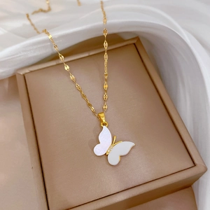 Titanium butterfly shell pendant necklace in gold finish on beige jewelry box display
