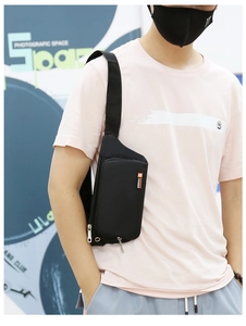 Close-up of black nylon crossbody bag worn by male model with zipper pocket detail