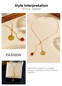 Macro detail of Y-shaped gold sun necklace with amber pendant and adjustable chain link