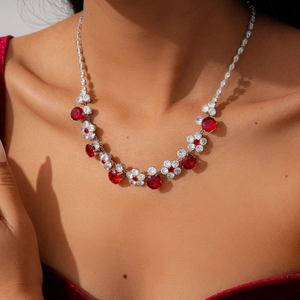 Close-up of elegant flower necklace with red gemstones and white zircon on a model