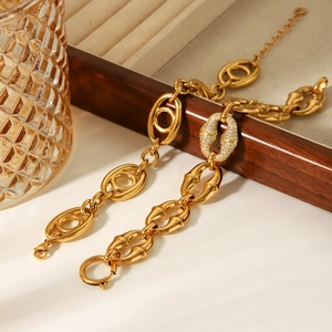 Détail macro du bracelet chaîne en acier inoxydable doré 18K avec anneau en cristaux