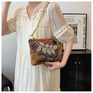 Detailed close-up of exquisite floral leaf embroidery on a brown sequin evening clutch