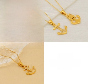 Detail of gold nautical anchor pendant necklace with zircons and stainless steel texture