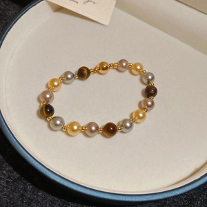 Vue détaillée du bracelet en œil de tigre et perles avec un fermoir magnétique doré chic
