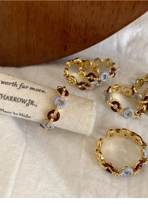 Macro shot of gold-plated chain ring with colored enamel and sparkling zircon accents