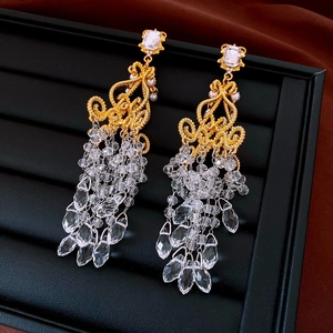 Macro shot of gold-plated hollow diamond pattern earrings with crystal bead tassels